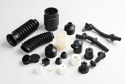 examples of rubber bellows, grommets and rubber plugs that make up custom molded rubber parts all laid out on a table